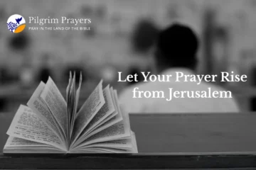 Hands folded in prayer beside a Bible and laptop, symbolizing faith and online prayer connection to Jerusalem.