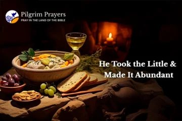 Loaves and fishes on a rustic table, symbolizing Jesus’ miracle of abundance from a small offering