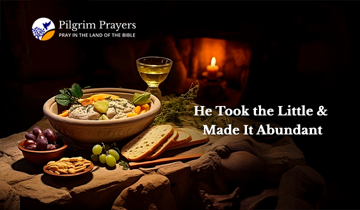 Loaves and fishes on a rustic table, symbolizing Jesus’ miracle of abundance from a small offering