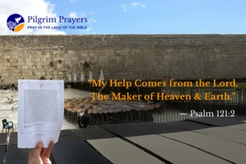 Hand holding a prayer at the Western Wall in Jerusalem, seeking God’s help