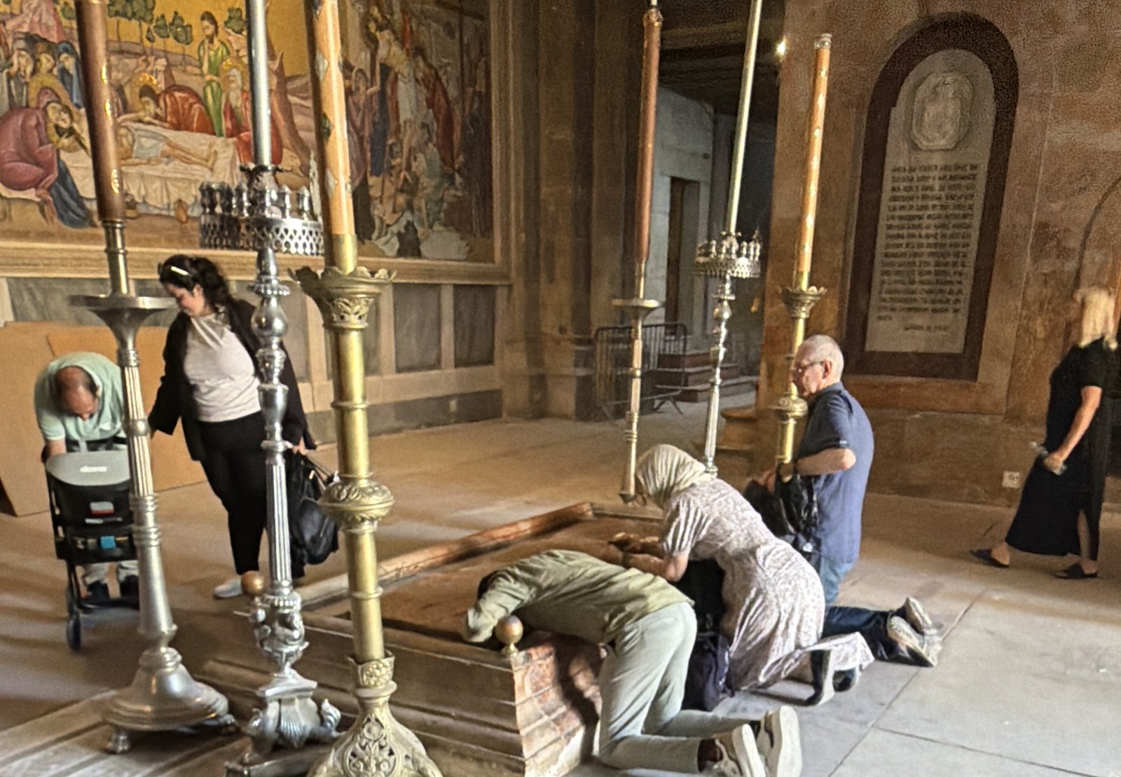 Pilgrims kneeling at the Stone of Unction in the Church of the Holy Sepulchre